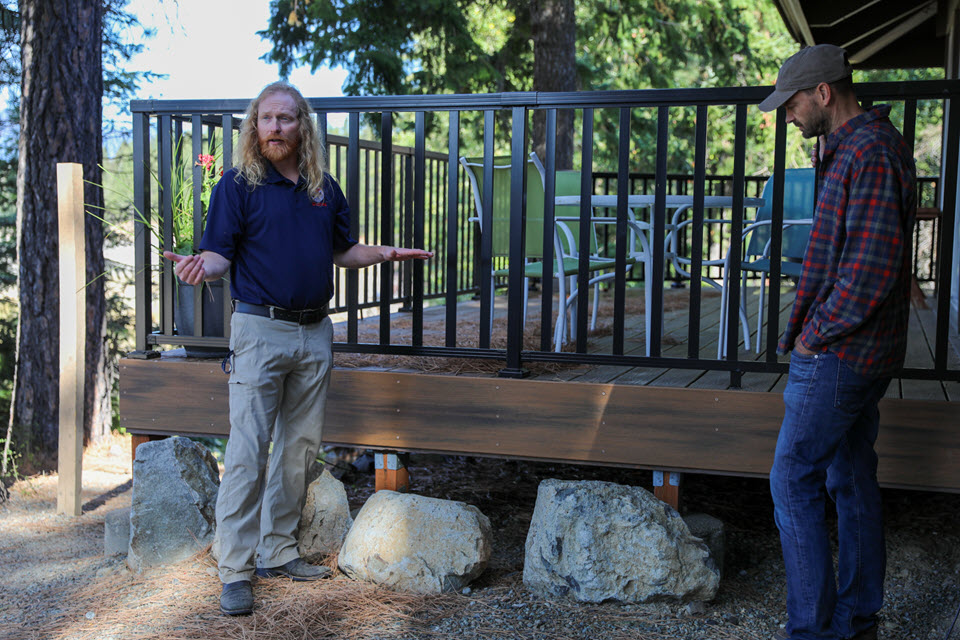 Jake Hardt, left, a community resilience coordinator at the DNR, gives a demonstration of a home assessment at a community building near Cle Elum in October 2022 with community captain Jeremy Baker at a Wildfire Ready Neighbors event.